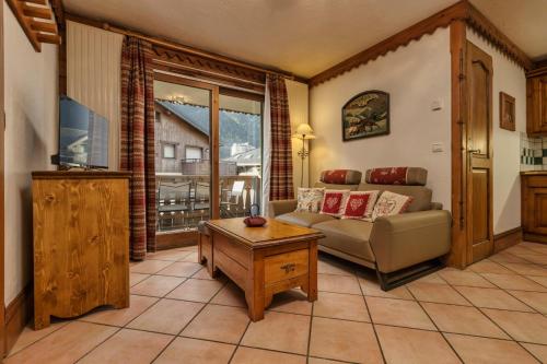 ein Wohnzimmer mit einem Sofa und einem Tisch in der Unterkunft City Center Apart, Swimmingpool , Free Parking in Chamonix-Mont-Blanc