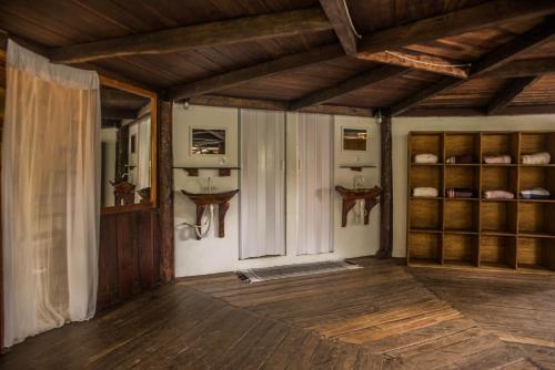 un soggiorno con pavimenti in legno e soffitti in legno. di Casa Conduru a Itacaré