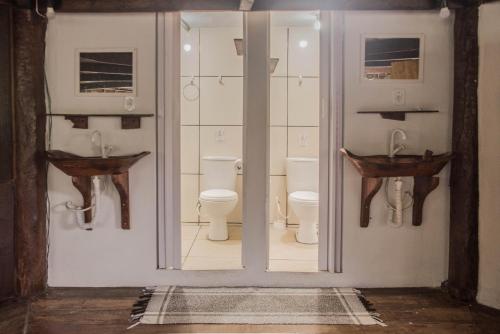 ein Badezimmer mit zwei Waschbecken und einem WC in der Unterkunft Hostel Casa Conduru in Itacaré