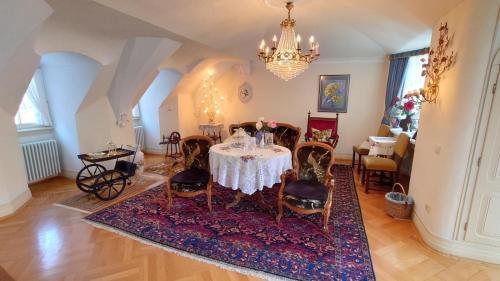 a dining room with a table and chairs and a chandelier at Hotel zum Riesen in Miltenberg