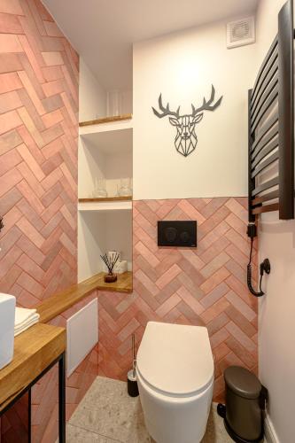a bathroom with a white toilet and a wall at Pod Gołębiem Contactless check in 24h in Karpacz