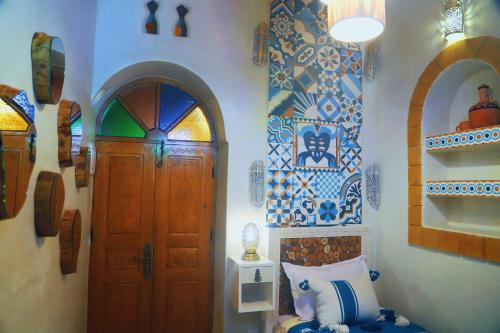 een kamer met een deur en wat tegels op de muur bij Riad Milal in Essaouira