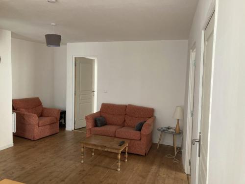 a living room with two red couches and a table at Apartment Centre Historic in Marvejols