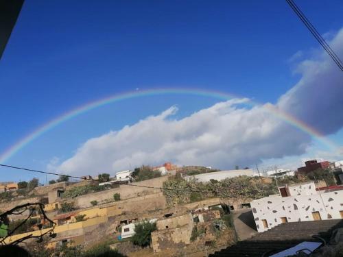 a rainbow in the sky over a city at Studio Canario in El Escobonal