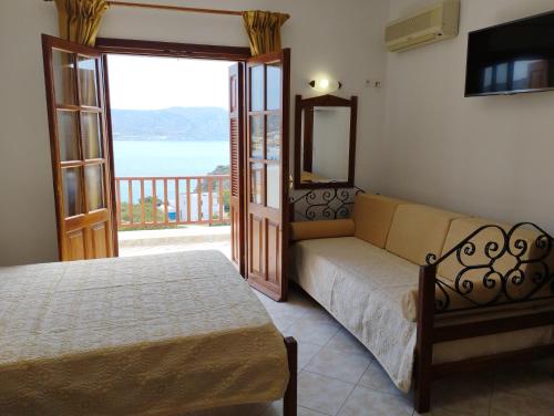 a bedroom with a couch and a view of the ocean at Olympos Studios in Amoopi