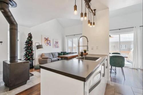 a kitchen and living room with a christmas tree at INITIAL - PETIT BONHEUR - Mont-Sainte-Anne in Beaupré