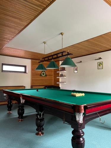 a pool table in a room with a ceiling at Приватний будинок для сімейного відпочинку з басейном і сауною in Hryhorivka