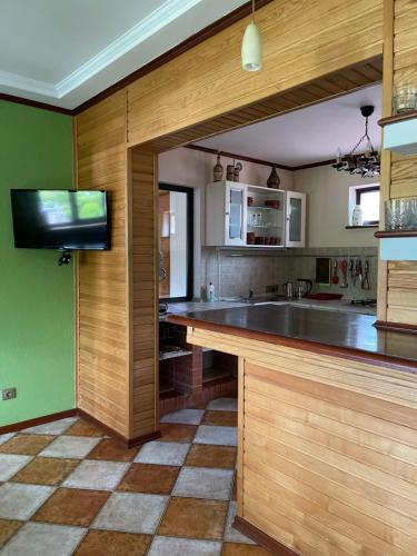 a kitchen with wooden cabinets and a large counter top at Приватний будинок для сімейного відпочинку з басейном і сауною in Hryhorivka