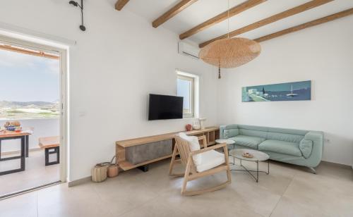a living room with a couch and a tv at Milos Zen Suites in Adamas
