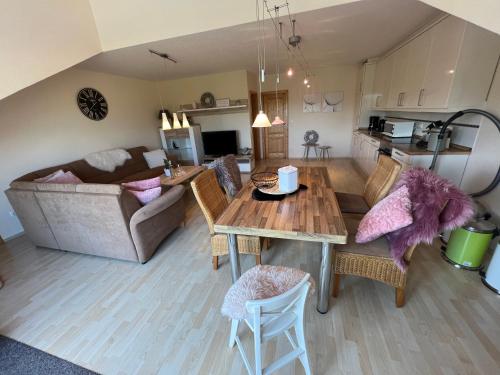 a living room and kitchen with a table and a couch at Schmidt's Plaats in Norden