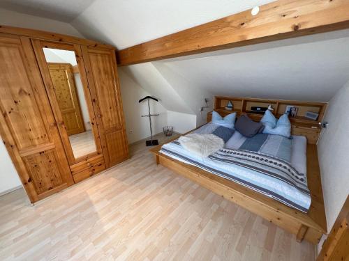 1 dormitorio con 1 cama grande con marco de madera en Schmidt's Plaats, en Norden