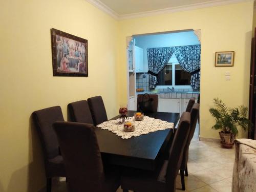 a dining room with a black table and chairs at Alexadra's house Κάτω Αλμυρή in Kato Almiri