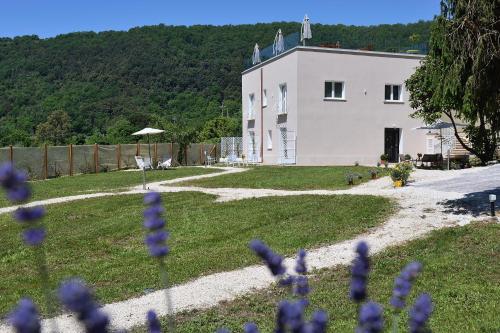 Biały dom z fioletowymi kwiatami przed nim w obiekcie il Lago di Nemi w mieście Nemi