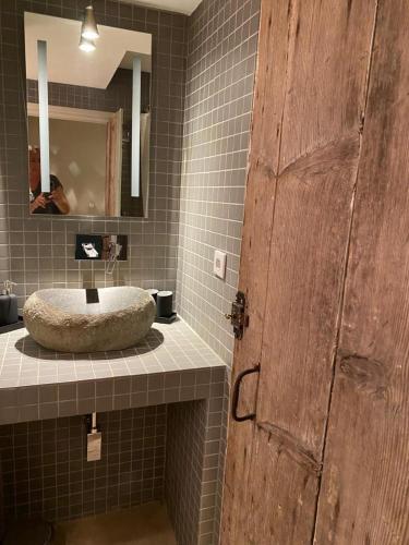 La salle de bains est pourvue d'un lavabo et d'une porte en bois. dans l'établissement Studio de l'Atelier d'Artiste, à Avignon