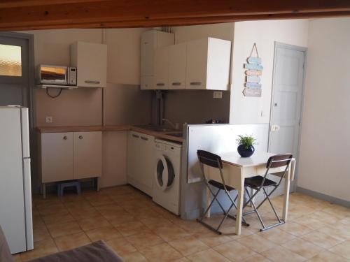 a kitchen with a table and chairs and a refrigerator at Le Fontana in Nice