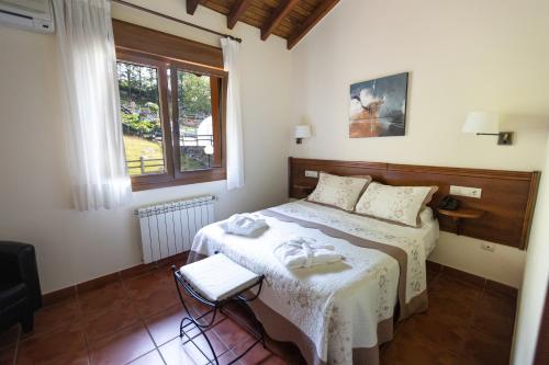 a bedroom with a bed and a window at Hotel & Spa Villa de Mestas in Cangas de Onís