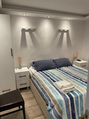 a bedroom with a bed with a striped blanket and lights at Taksim home in Istanbul