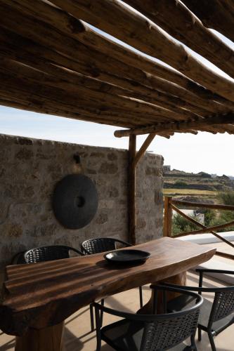 a wooden table and chairs on a patio at Ikies of Mykonos in Mýkonos City