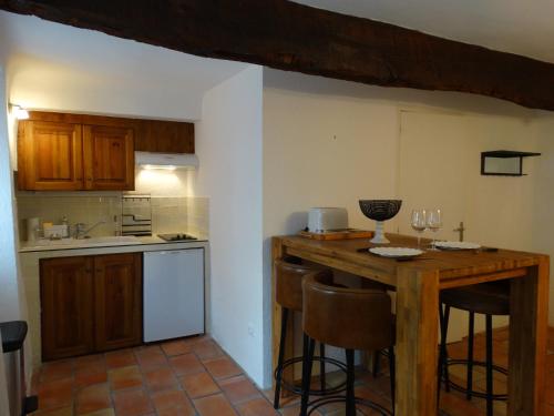 une cuisine avec une table en bois et quelques chaises dans l'établissement Le Clos du Tilleul, à Saint-Michel-lʼObservatoire