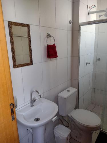 a bathroom with a toilet and a sink and a mirror at Kitnet top 04 Prox do centro e da UEM in Maringá