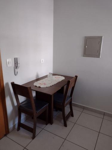 una mesa de madera y 2 sillas en una habitación en Kitnet top 04 Prox do centro e da UEM en Maringá