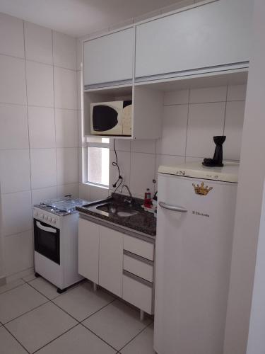 eine kleine Küche mit einem Kühlschrank und einem Herd in der Unterkunft Kitnet top 04 Prox do centro e da UEM in Maringá