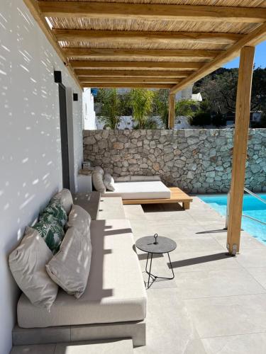 a patio with a couch and a table and a pool at Milos Villas Complex in Pefki Rhodes