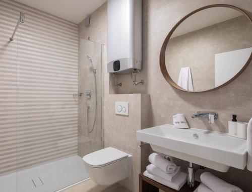 a bathroom with a sink toilet and a mirror at Villa Mirta in Bol