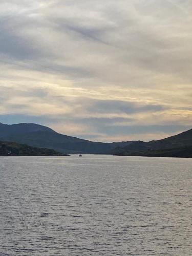 a large body of water with mountains in the background at Racecourse Lodge Apartment in Clifden