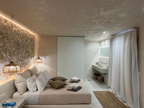 ein Schlafzimmer mit einem Bett mit Kissen und einem Waschbecken in der Unterkunft Milos Villas Complex in Pefki Rhodes