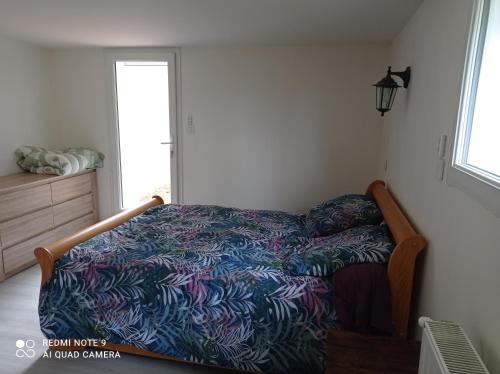 1 dormitorio con 1 cama con un edredón colorido en L'Eclat de menthe, en Augerolles