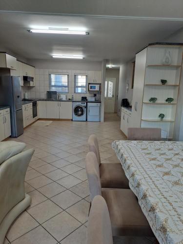 a large kitchen with a table and chairs in a room at Beach Hive 1 in Swakopmund
