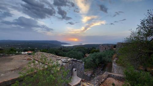 a view of a sunset from a building with a guitar at Elgina Apartments2 MANI in Mína