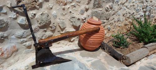 a large orange vase with a wooden object next to a wall at Elgina Apartments2 MANI in Mína