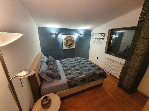 a bedroom with a bed and a blue wall at La Grande Apartments in Kotor