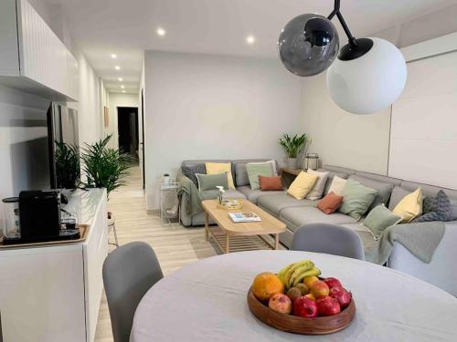 a living room with a table with a bowl of fruit at YELLOW SAIL MÉDANO 2 Dormtiorios con parking in El Médano
