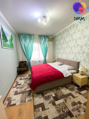 a bedroom with a bed with a red blanket at Dimm Отель in Almaty