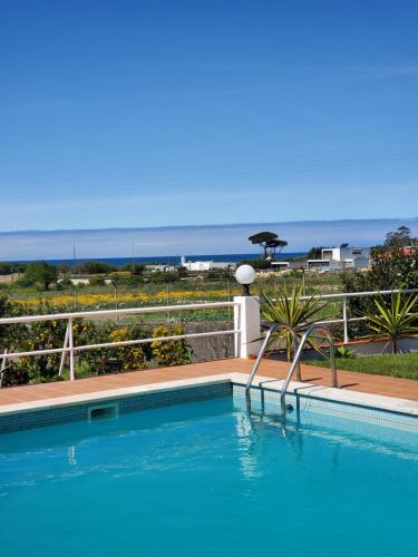 a swimming pool with a view of the ocean at Casa Milia Orange in Marinhas