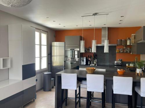 - une cuisine avec une table et des chaises blanches dans l'établissement Appt avec jardin et clim proche Arènes de Cimiez, à Nice