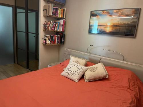 - une chambre avec un lit orange et 2 oreillers dans l'établissement Appt avec jardin et clim proche Arènes de Cimiez, à Nice