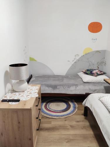 ein Schlafzimmer mit einem Bett und einem Tisch mit einer Lampe in der Unterkunft Wellspring in Radom