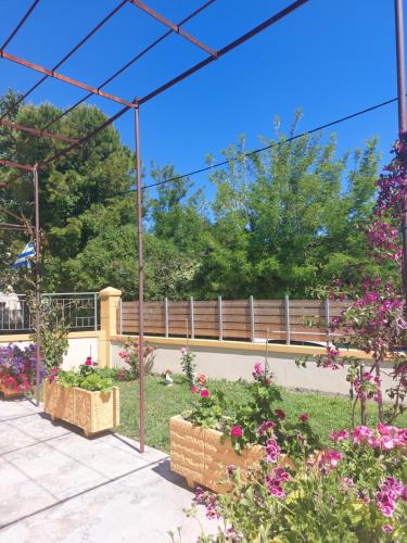 a garden with flowers and a bridge in the background at Villa Fotini in Sami
