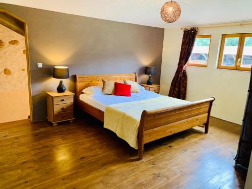 ein Schlafzimmer mit einem Holzbett mit zwei Nachttischen und zwei Lampen in der Unterkunft Gîte Bidallon in Saint-Michel-Saint-Jaymes