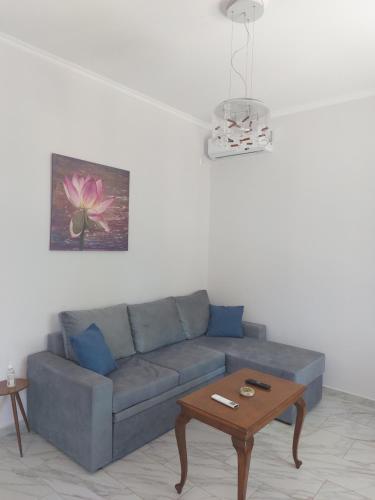 a living room with a blue couch and a table at Villa Fotini in Sami