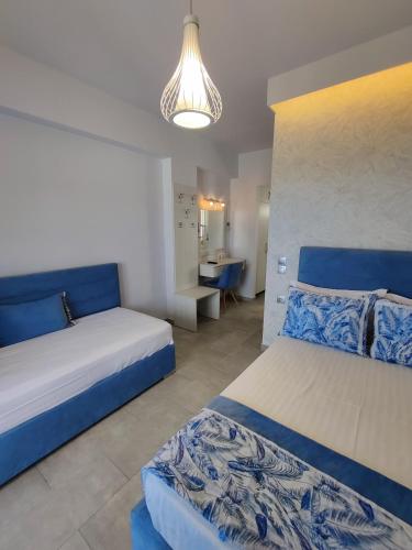 a bedroom with two beds and a chandelier at Studios Apollon in Chrysi Ammoudia