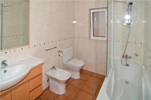 a bathroom with a sink and a toilet and a shower at 609 Villa Mariposa in Lagos