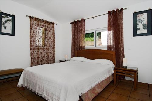 a bedroom with a bed and two windows at 609 Villa Mariposa in Lagos