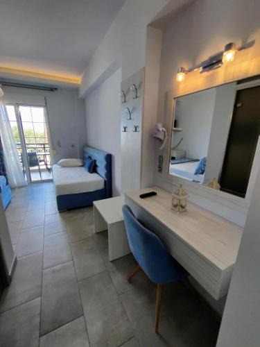 a room with a desk and a bed and a mirror at Studios Apollon in Chrysi Ammoudia