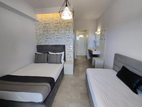 a bedroom with two beds and a couch at Studios Apollon in Chrysi Ammoudia