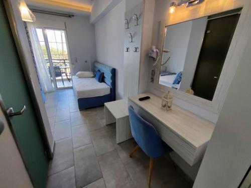 a room with a desk and a mirror and a bed at Studios Apollon in Chrysi Ammoudia